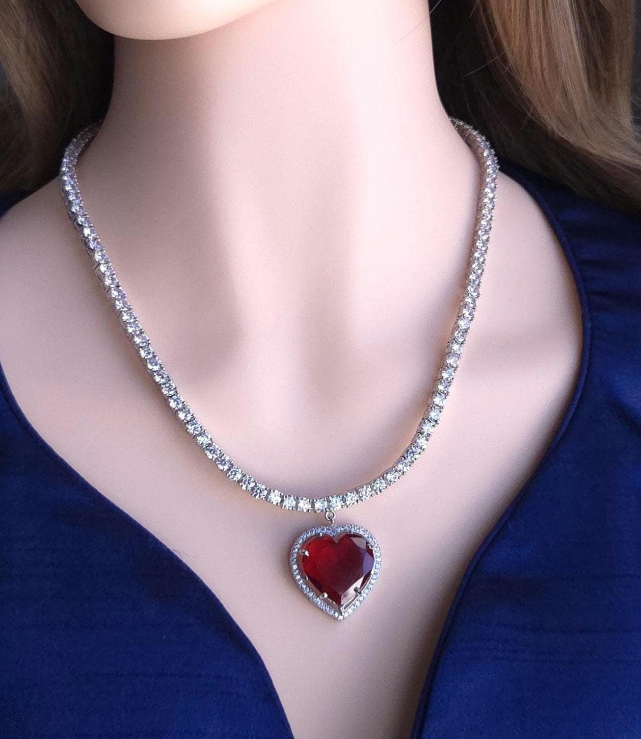 Custom layered tennis chain layout with central red heart crystal gem