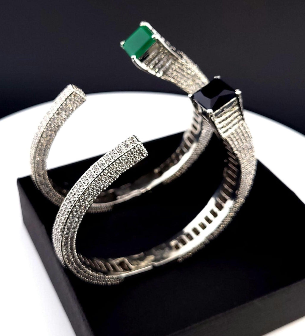 Modern open hook silver tone cuff bangle with deep emerald accent slot
