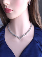 Mannequin wearing a diamond necklace and earrings against a dark background