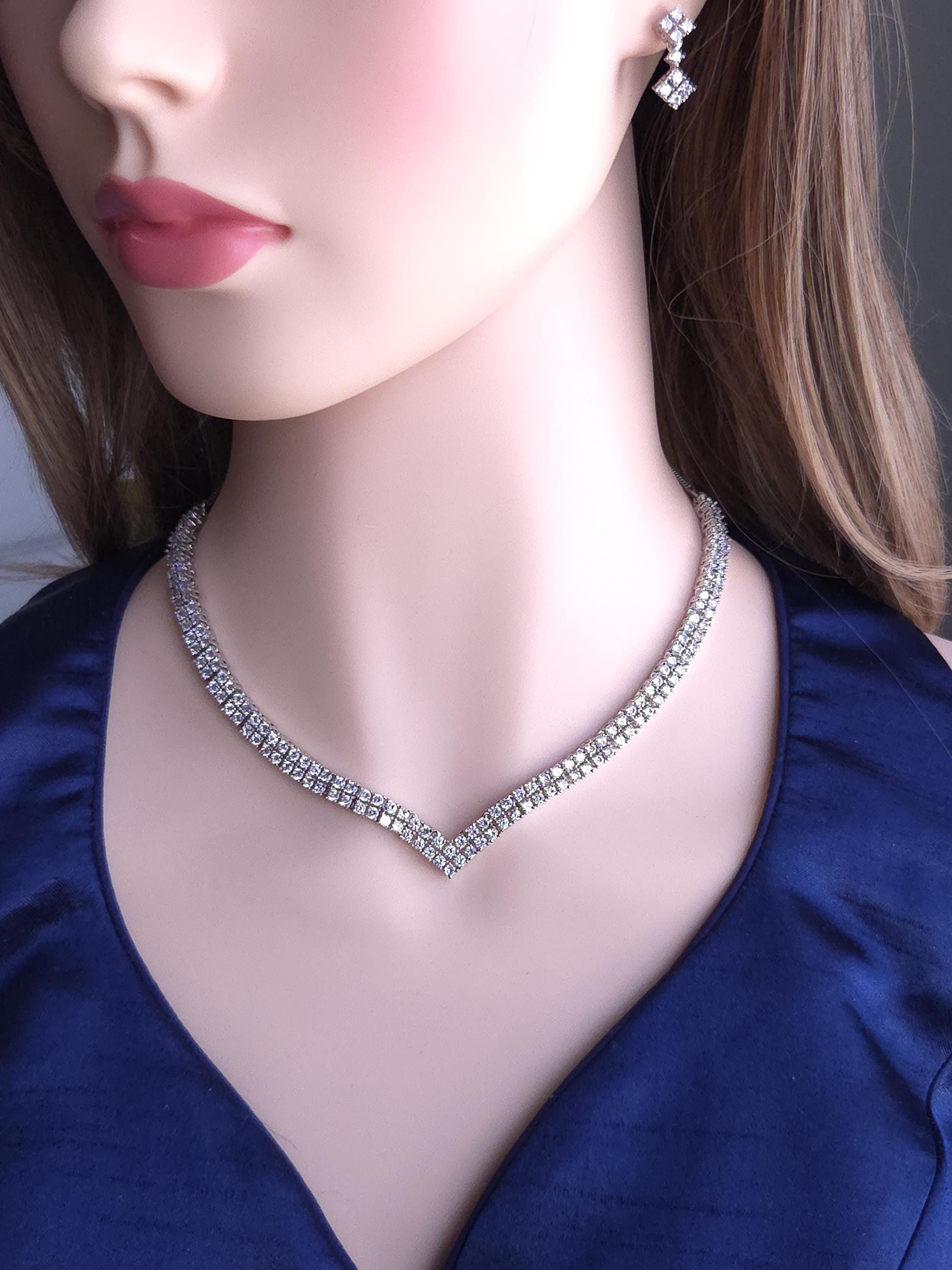 Mannequin wearing a diamond necklace and earrings against a dark background