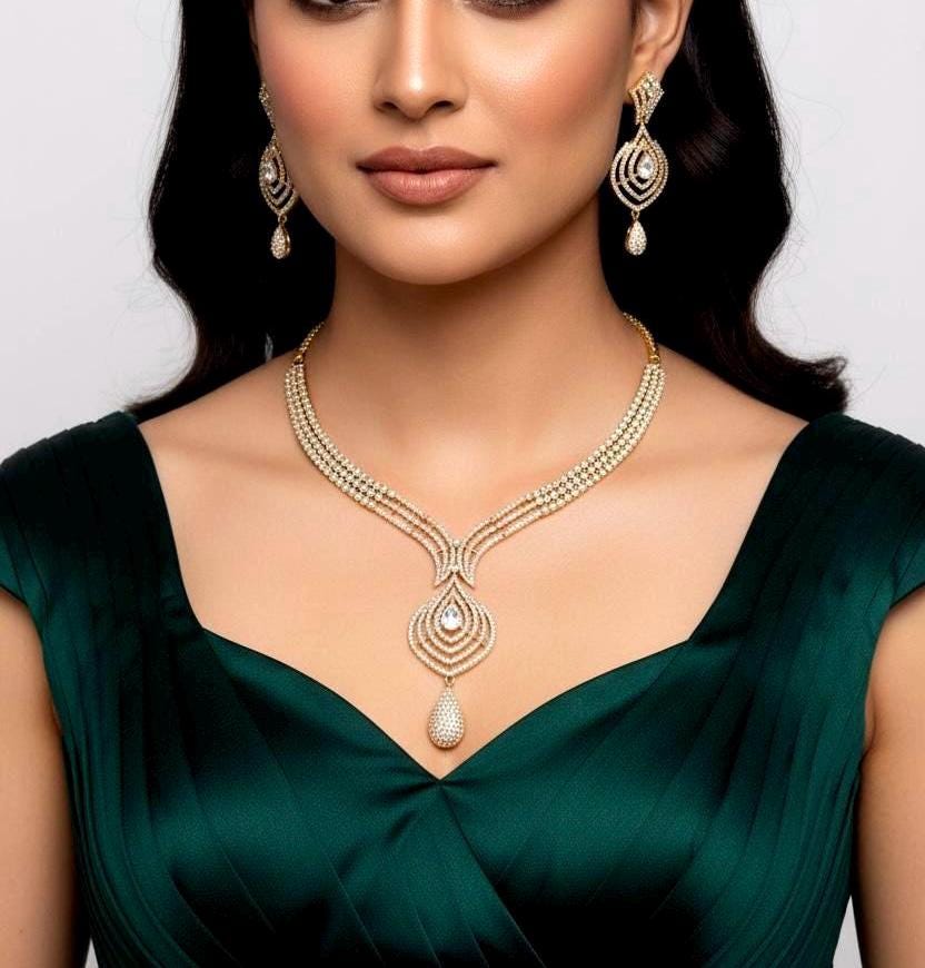 Woman wearing a gold necklace and earrings on a plain background