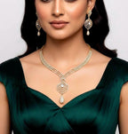 Woman wearing a gold necklace and earrings on a plain background