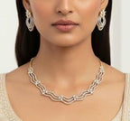 Woman wearing a diamond necklace and earrings on a white background