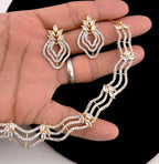 Jewelry set including necklace, earrings, and ring on a hand against a black background