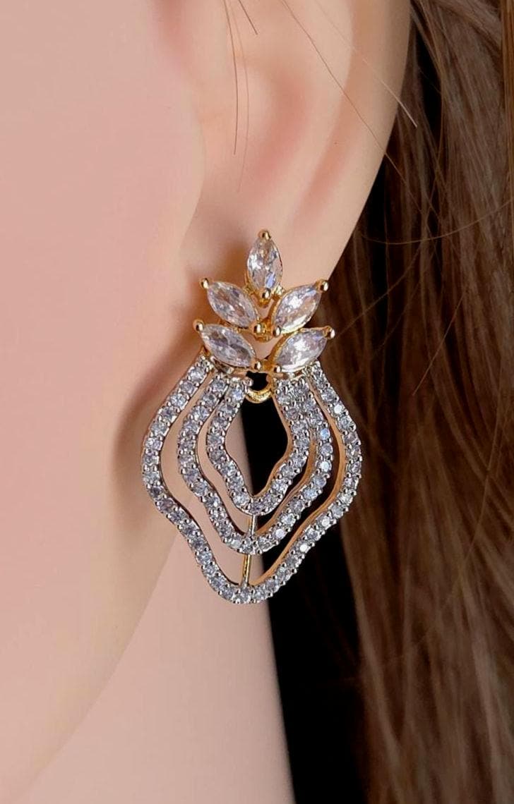 Elegant earring worn on a model's ear with a neutral background