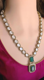 Necklace with green pendant on a mannequin wearing a pink top