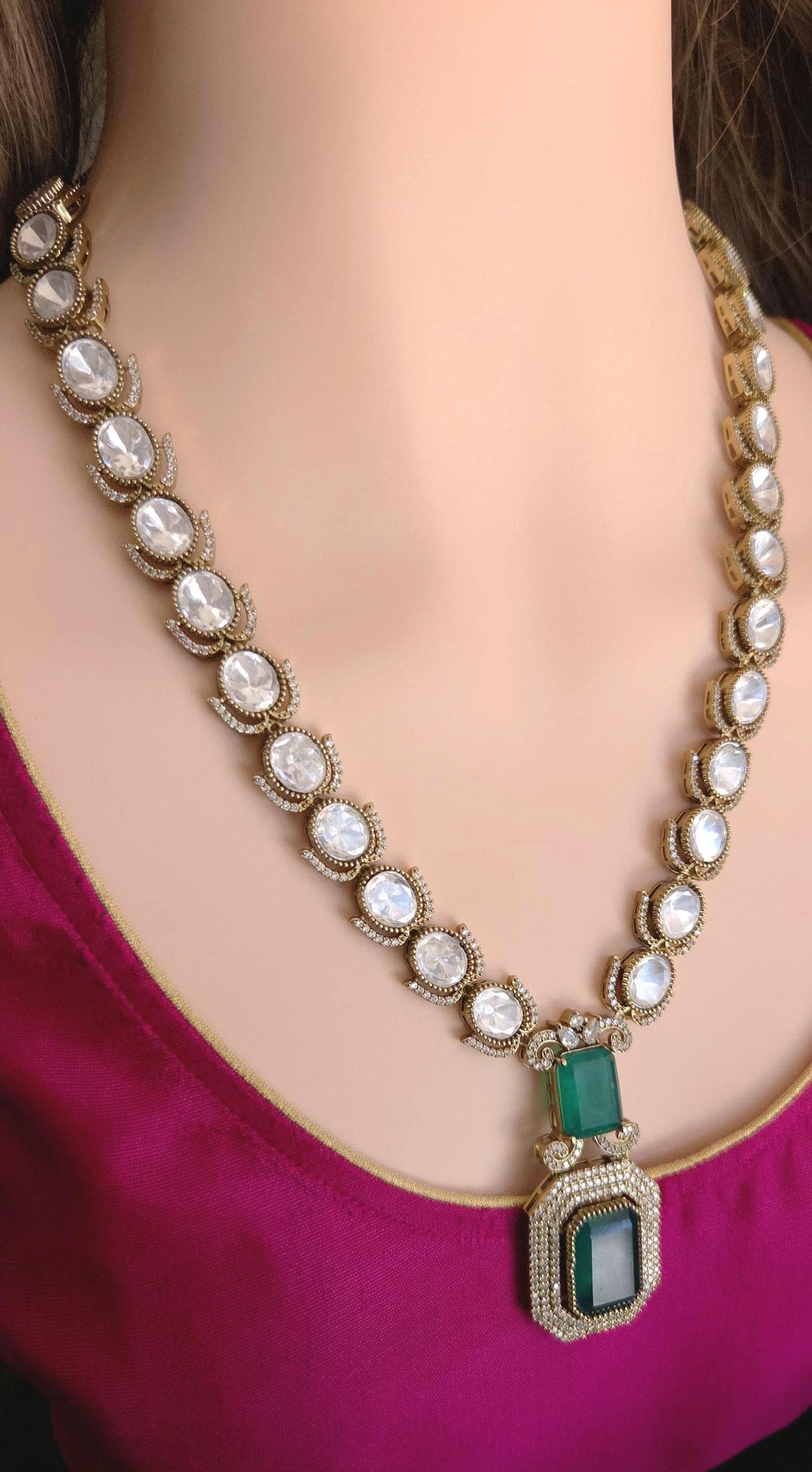 Necklace with green pendant on a mannequin wearing a pink top
