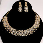 Gold necklace and earrings set on a black stand