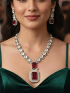 Woman wearing a luxurious diamond and red gemstone necklace with matching earrings.