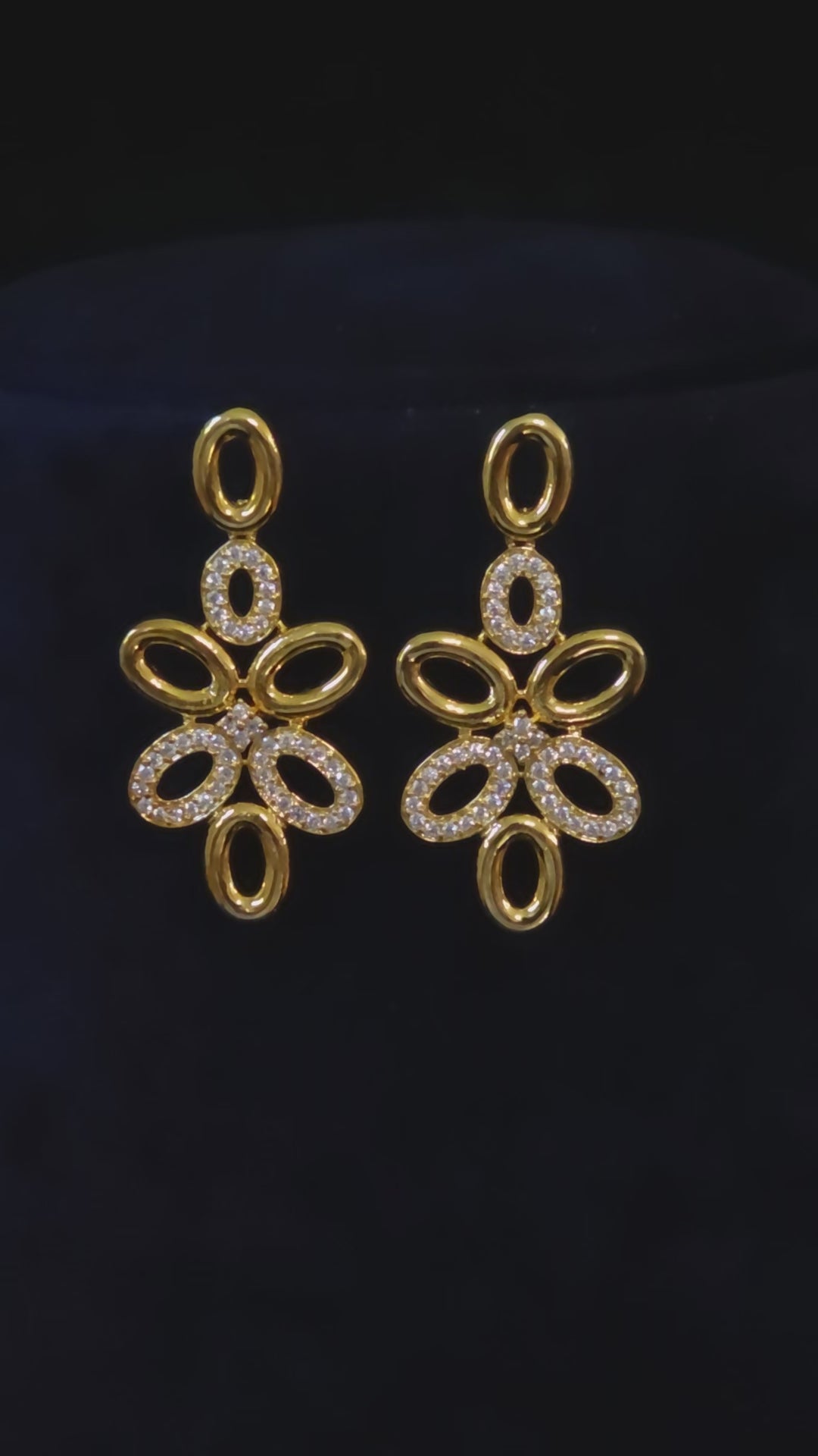 Modern gold-plated CZ oval-link necklace and matching drop earrings shown in an elegant jewelry styling vide