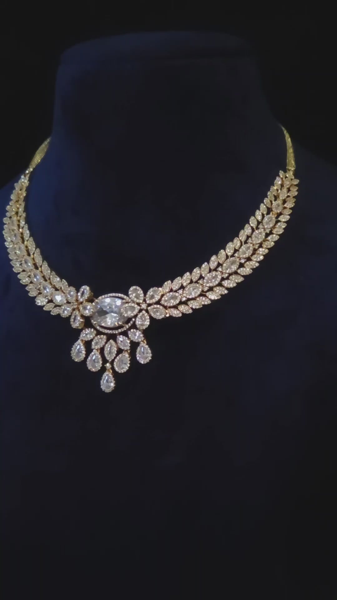  Nooraya triple 18K gold-plated, premium-quality CZ leaf necklace with matching floral drop earrings styled on a model.