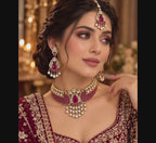 video showcasing Traditional bridal necklace set with wine-red stones, clear accents, matching chandelier earrings, and maang tikka 