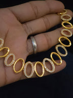 A gold oval-link necklace with alternating links set with small clear stones
