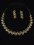 A gold and silver geometric jewelry set featuring a necklace and matching drop earrings, displayed on a black background.