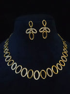 Gold-tone jewelry set featuring a matching necklace and earrings with oval links, displayed on a black velvet mannequin bust.