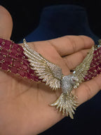 Close-up of ruby CZ collar necklace showing the pave bird pendant with spread wings