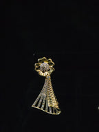 A gold-tone flower-shaped brooch with a dangling tassel design, embellished with clear rhinestones, displayed on a black background.