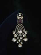 Close-up of a pear and rose-cut CZ chandelier earring with ruby accent