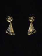 A pair of gold-toned statement earrings with a flower-shaped top set with clear stones and a textured, fan-like drop below, displayed against a solid black background.
