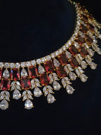 Close-up of gold-plated ruby CZ bridal choker showing emerald-cut red stones and marquise clear CZ drops