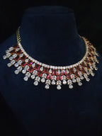 Gold-plated ruby CZ bridal choker with emerald-cut red stones and clear CZ fringe drops on a mannequin bust
