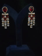 Close-up of a gold-plated ruby CZ chandelier earring with rectangular red stones and layered clear CZ tassels
